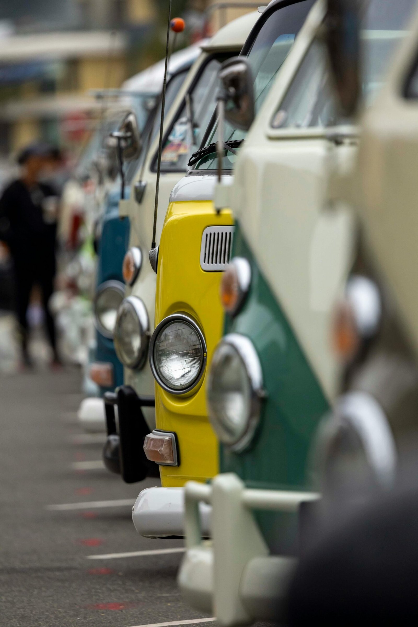 A vibrant lineup of classic camper vans in various colors parked in a row.